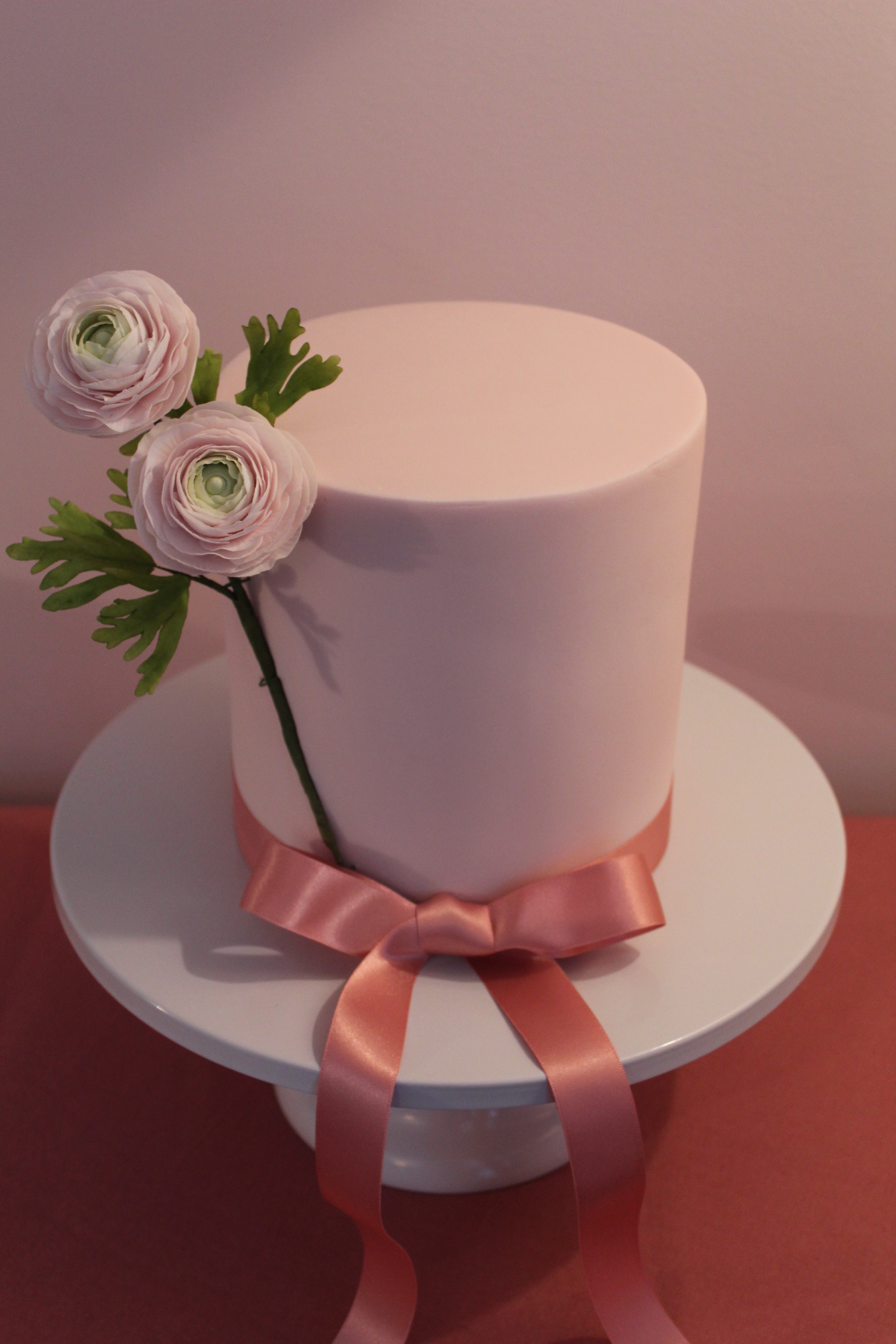 Sugar ranunculus on a rich chocolate cake with white chocolate ganache and fondant icing.